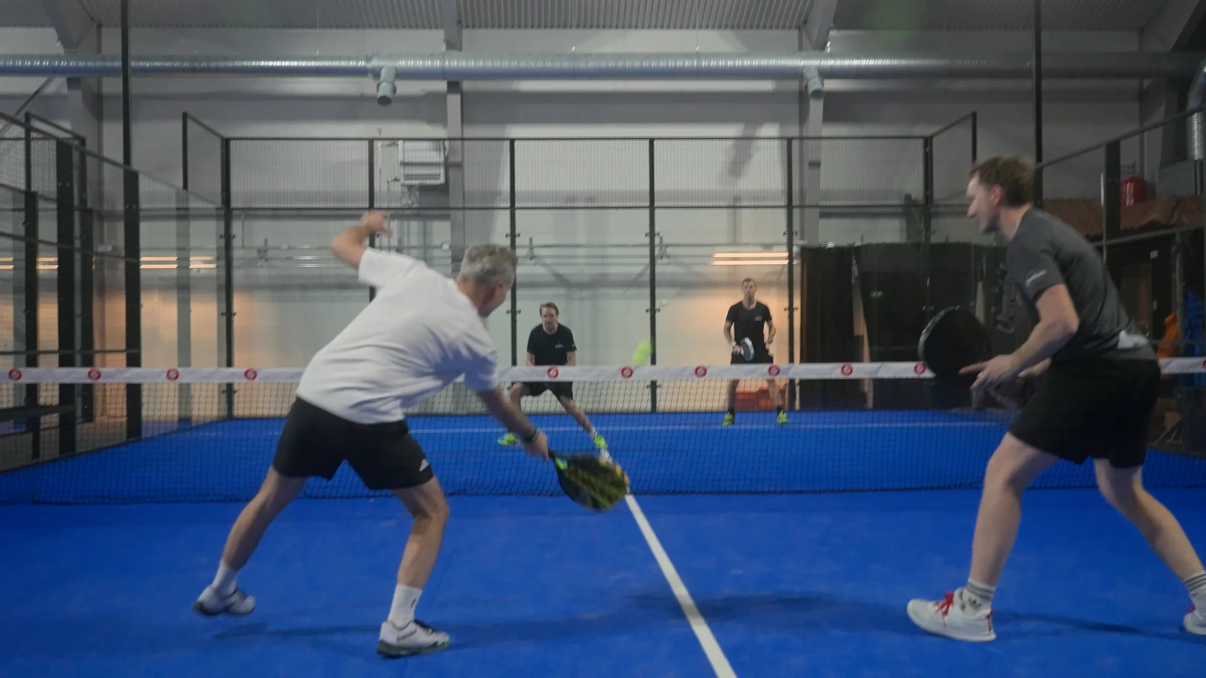 Fyra spelare mitt i en padelmatch på en av Vemdalen Arenas blå banor.